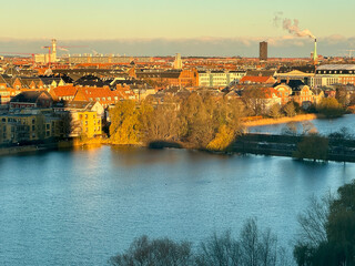 Obraz premium Morning light illuminating thew city of Copenhagen sun de morning. Warm orange light shines on architectural buildings and houses. Crisp clear blue sky