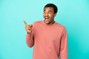 Fototapeta premium African American handsome man on isolated blue background intending to realizes the solution while lifting a finger up
