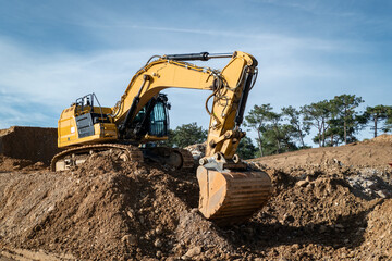 Retroescavadora giratória a escavar a terra para a construção de uma estrada