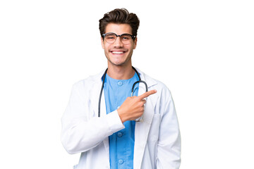 Young doctor man over isolated background pointing to the side to present a product