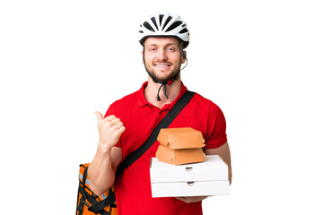 Young delivery man taking a takeaway food over isolated chroma key background pointing to the side...