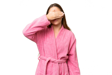 Young woman in a bathrobe over isolated chroma key background covering eyes by hands. Do not want to see something
