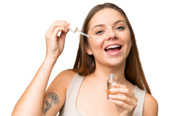 Young blonde woman over isolated chroma key background holding a serum while smiling. Close up portrait