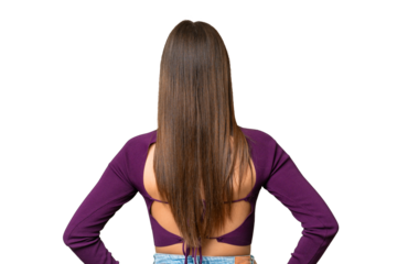 Young beautiful woman over isolated chroma key background in back position