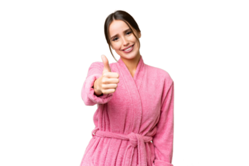 Young beautiful woman in a bathrobe over isolated chroma key background with thumbs up because something good has happened