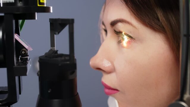 Eye examination and optometry to test your vision, medical consultation or glaucoma screening. Happy client with laser technology or eye scanning and ophthalmic test machine