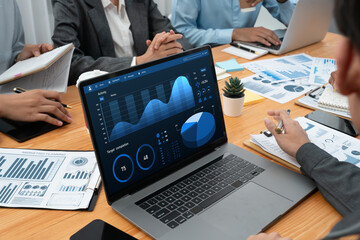 Multiracial analyst team use BI Fintech software to analyze financial data on meeting table....