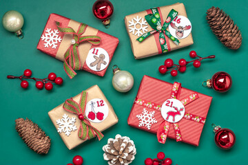 Handmade wrapped red, green gift boxes decorated with ribbons, snowflakes and numbers, Christmas decorations and decor on green table Xmas advent calendar concept Top view Flat lay Holiday card - 685041687