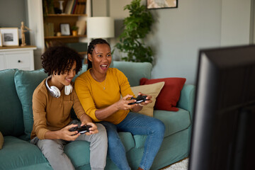 Mother and son playing video games at home