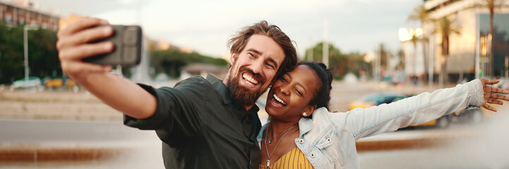 Closeup of smiling interracial couple taking a selfie on fountain background. Close-up, man and...