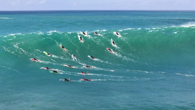 big wave come in and surfers paddle hard