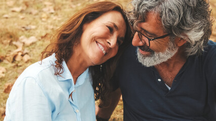 Close-up of happy retired couple spending time together, smiling and relaxing while sitting on the...