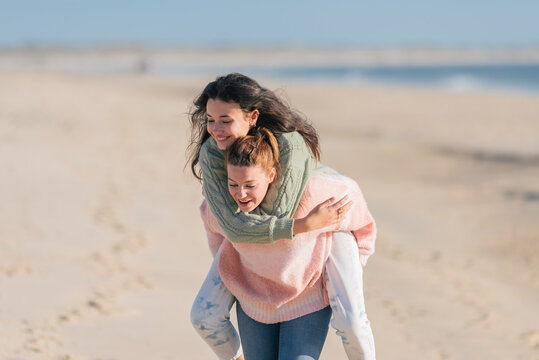 Happy lesbian woman giving piggyback ride to girlfriend - Powered by Adobe