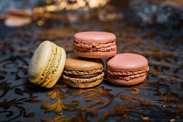 Colorful sweet macaroons on the table and golden table runner