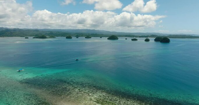 Blue sea surface and cluster of small islets. Blue sky and clouds. Britania Islands. Surigao del Sur, Philippines.