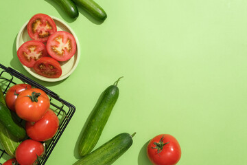 Light green background featured tomatoes and cucumbers placed on a dish and contained in a basket....