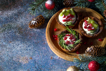 Christmas nut tartlets. Delicious, beautiful cupcakes are decorated with Christmas garlands and Christmas tree branches. Selective focus. Copy space