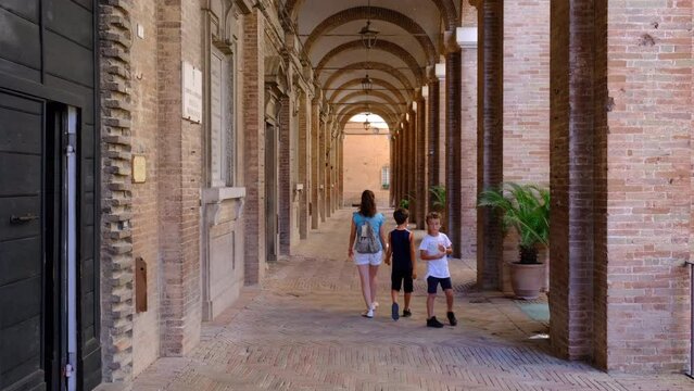Tourists stroll among the arcades of Corinaldo, Marche Italy.