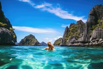 Fotobehang Young woman in the lagoon of El Nido, Palawan, Philippines, A young woman swimming in clear sea water in a lagoon and looking at a beautiful landscape, AI Generated © Ifti Digital