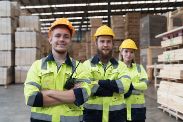 Warehouse and factory concept. Group of male and female warehouse workers standing together with crossed arms in wood storage warehouse
