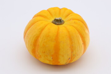 白背景の上に乗った黄色いカボチャ