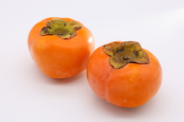 白背景の上に乗ったオレンジ色の柿