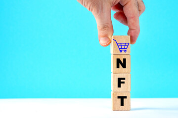 Wooden cubes with word NFT.hand, trolley