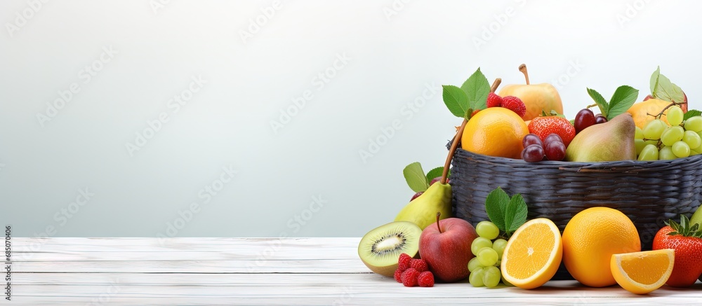 Poster fruits in wicker basket on white wooden table copy space image