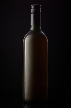 Bottle of unbranded wine on a black background.
