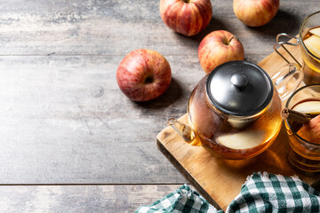 Autumn hot apple drink with spices on wooden table. Copy space