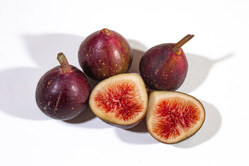 Figs are served dark purple, with a beautiful bright red filling, on a plain white background