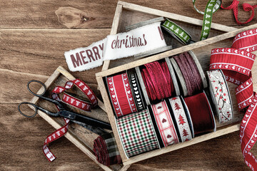 Natural Christmas background, banner. Christmas ribbons on wooden background and antique scissors on a small wooden tray. Christmas gift wrapping.