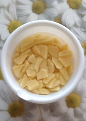 a bowl of sliced potatoes, in water, a close-up image of food,  preparation for cooking
