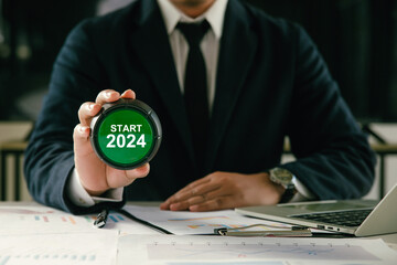 Businessman holding the green button with text start 2024 idea for 2024 new year goal plan action,...