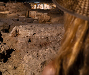 Blond woman with straw hat looking at the ruins and religious wall paintings and frescoes of the...