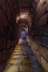 Fototapeta na wymiar Illuminated corridor of stone blocks and rock stairs from the exit of the water algive of the Arab citadel of Mérida. Province of Badajoz, Extremadura, Spain.
