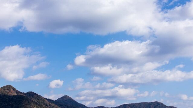 山頂と青空に流れる白い雲のタイムラプス