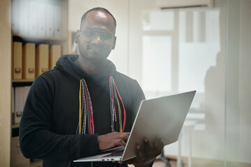 Portrait of senior developer with laptop committing programming code
