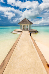 Scenic view of beach hut in Maldives with turquoise water and dramatic sky