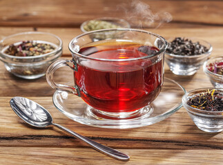 Cup of tea and dry teas on wooden background. Top view.