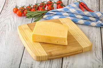 Piece of natural organic cheese over board