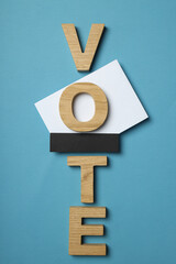 Wooden letters and voting form on blue background, top view