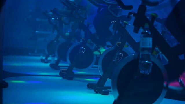A group of people work out at a fitness center on exercise bikes