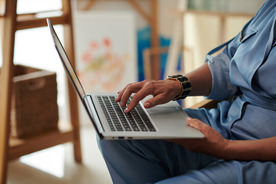 Cropped image of mature woman working on laptop in her studio