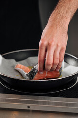 Man cooking salmon steak roasting on parchment paper