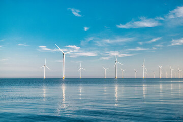 offshore windmill park with stormy clouds and a blue sky, windmill park in the ocean of the...
