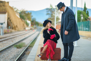 An engaged couple waiting for the train at the station