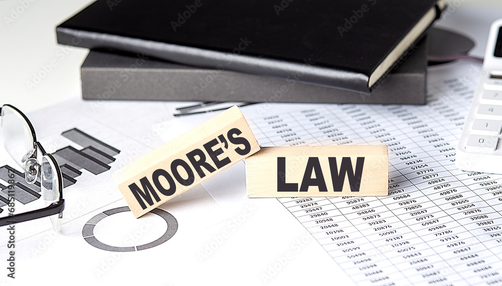 Aufkleber moore's law - text on a wooden block with chart and notebook