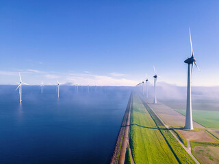offshore windmill park with clouds and a blue sky, windmill park in the ocean aerial view with wind...