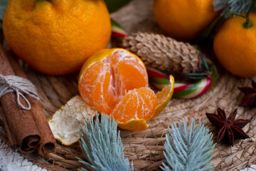 New Year's tangerines on the table with decorative Christmas trees. Festive atmosphere with white burning candles in the background